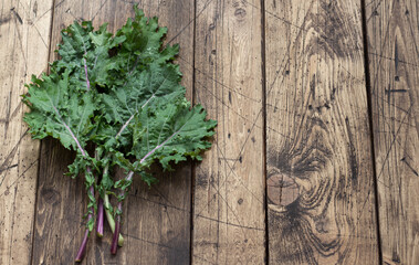 Fresh kale leaves on the wooden background. top view. space. rustic style. healthy food. superfood