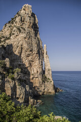 Fototapeta na wymiar Sea in Sardinia with a rocks and mountain around the blue sea.
