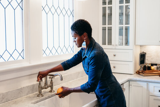 Mom washes fruit in kitchen and prepares a snack