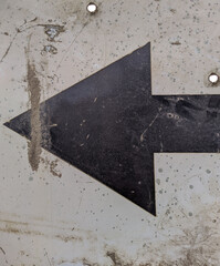 old and black metal arrow sign points to the left