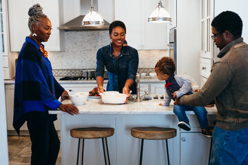 Multigenerational black family in kitchen cooking meal
