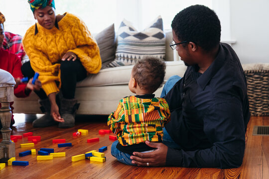 Black family playing with blocks in living room