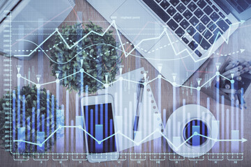 Multi exposure of financial chart hologram over desktop with phone. Top view. Mobile trade platform concept.