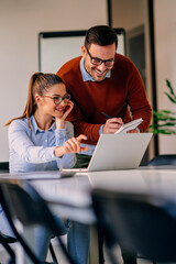 Businesswoman helping her colleague to write down the notes