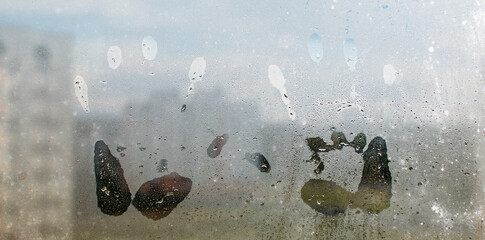 A child's handprint on the fogged glass