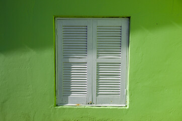 Janela branca em uma parede verde