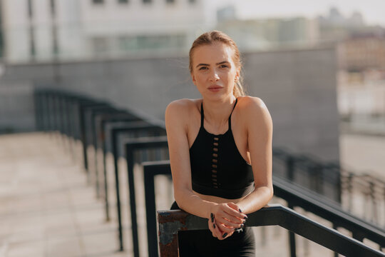 Expressing positivity, happiness of joyful young woman at training on seafront in early sunny morning. Confident pretty caucasian woman posing at camera - Powered by Adobe