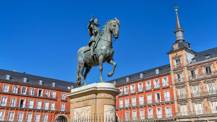 Plaza Mayor - Bright Autumn sunlight shines on the bronze equestrian statue of Philip III standing at the center of Plaza Mayor, Madrid, Spain.