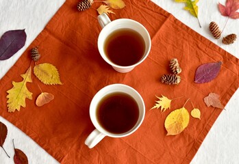 Warm fall beverage of hot tea with autumn leaves decor to sip and enjoy on cool seasonal days indoors