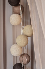 Cotton light balls in soft beige, brown and white colors in home interior for background. Copy space.
