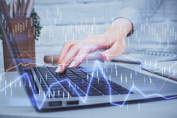 Multi exposure of woman hands typing on computer and forex chart hologram drawing. Stock market analysis concept.