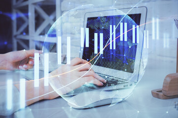 Double exposure of woman hands typing on computer and forex chart hologram drawing. Stock market...