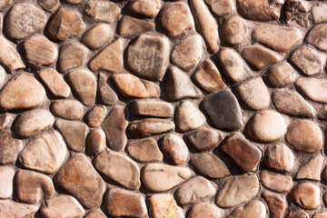 vintage antique wall from brown small rounded stones.
