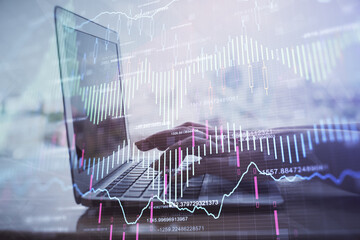 Double exposure of woman hands typing on computer and forex chart hologram drawing. Stock market...