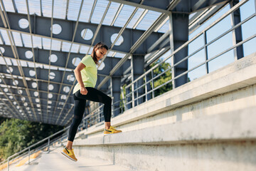 Active slim woman training muscles during jump squats