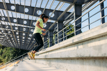 Energetic female jumping on stairs outdoors