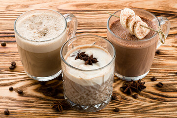 set of warm drinks on a wooden table, cocoa, hot chocolate and Glasse coffee