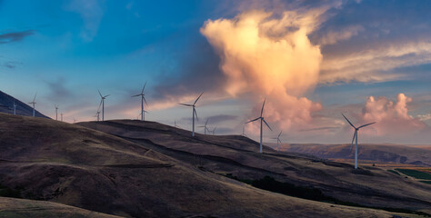 Beautiful Panoramic Landscape View of Wind Turbines on a Windy Hill during a colorful sunset....