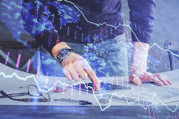 Double exposure of man's hands holding and using a digital device and forex graph drawing. Financial market concept.