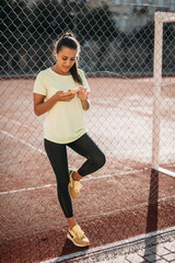 Obraz premium Beautiful woman using smartphone while relaxing at stadium