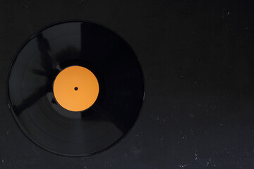 Vinyl record on a black background. Retro style. Top view.