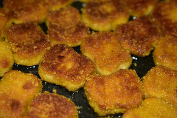 Cooking ruddy chicken nuggets in sunflower oil in a frying pan