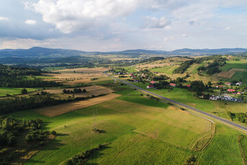 Hills and mountains among meadows. The meadows crossed by lines of trees constitute the landscape of the vicinity of Kamienna Góra in Poland © Ungrim