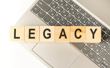 Word legacy. Wooden cubes with letters isolated on a laptop keyboard. Business Concept image.