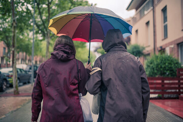 People walking in the rain carrying an umbrella.