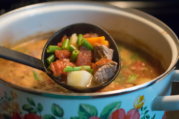 Homemade stew in large spoon. 