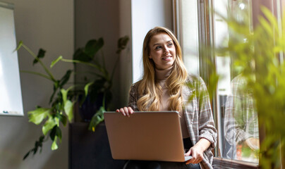 Shot of a young businesswoman with laptop in her office
