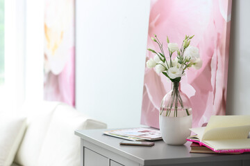 Composition of stylish vase with fresh flowers on grey table in living room. Space for text