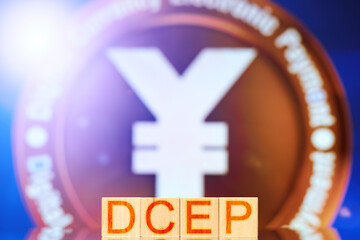dcep. wooden blocks with dcep lettering on digital yuan coin background