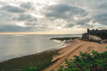 Empty Kingsgate Beach and Castle on the cliffs above the Bay, on cloudy autumn morning.