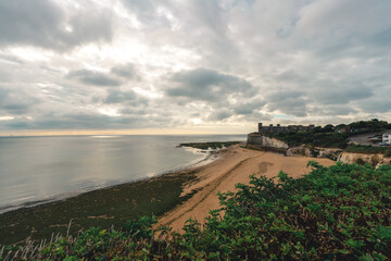 Empty Kingsgate Beach and Castle on the cliffs above the Bay, on cloudy autumn morning.