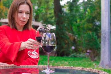 Girl in a red coat with a glasses of red wine