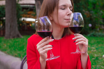 Girl in a red coat with a glasses of red wine