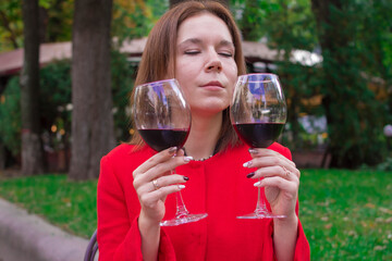 Girl in a red coat with a glasses of red wine