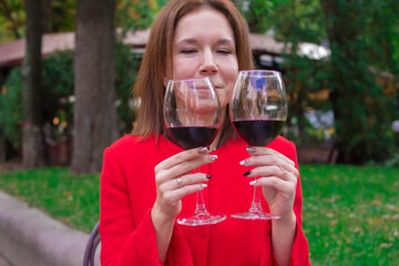 Girl in a red coat with a glasses of red wine