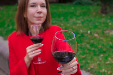 Girl in a red coat with a glasses of red wine