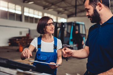 Female CNC machine operator consulting with supervisor