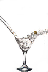 splash en copa de martini con aceituna volando