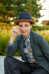 Business woman in a suit and hat. Beautiful lady with red lips looks at camera.