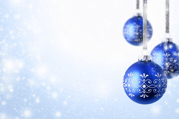 Christmas and New Year greeting card. Holiday ornament, winter decoration. Blue christmas balls hanging on ribbon over snow background, with copy space