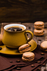 French Chocolate Macarons with Coffee Beans on Wooden Table. Selective focus.