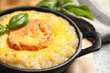Tasty homemade french onion soup served on table, closeup