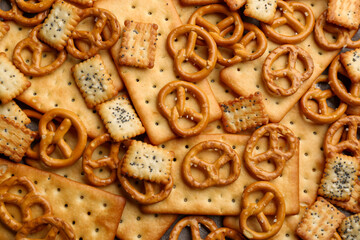 Many delicious crackers as background, top view