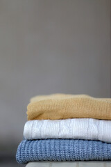 Stack of cozy sweaters. Selective focus.