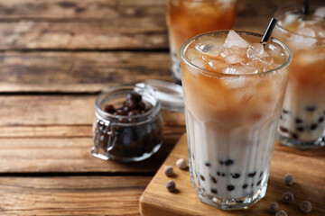 Tasty milk bubble tea on wooden table, closeup. Space for text