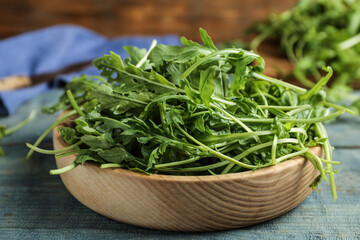 Fresh arugula on blue wooden table, closeup
